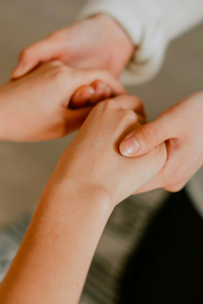 Zoom sur les mains jointes de deux personnes qui se soutiennent